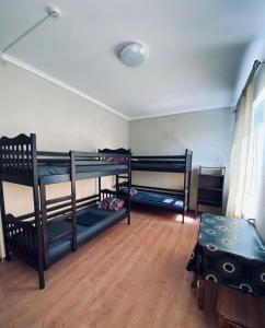 a room with three bunk beds and a table at Hostel Serge in Lviv