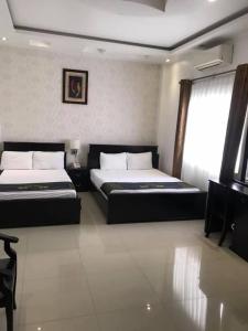 um quarto com 2 camas e uma janela em Khách Sạn Lệ Hằng em Mỹ Phước