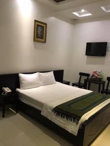 um quarto com uma cama e uma televisão na parede em Khách Sạn Lệ Hằng em Mỹ Phước