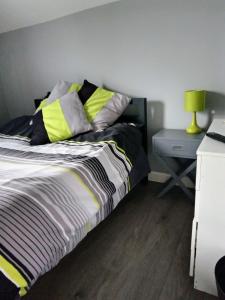 ein Schlafzimmer mit einem Bett und einem Tisch mit einer Lampe in der Unterkunft Bromley in Bickley