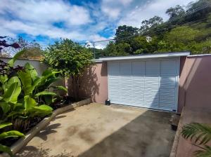 a garage with a roll up garage door at Studio completo com ar, garagem e varanda espaçosa em Itaipuaçu - Ideal para 3 pessoas in Maricá