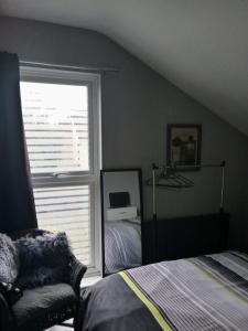 ein Schlafzimmer mit einem Fenster, einem Bett und einem Fenster in der Unterkunft Bromley in Bickley