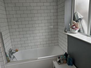 Baño blanco con bañera y lavamanos en Bromley en Bickley