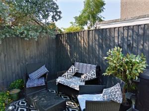 une terrasse avec 2 chaises et une clôture dans l'établissement Bromley, à Bickley