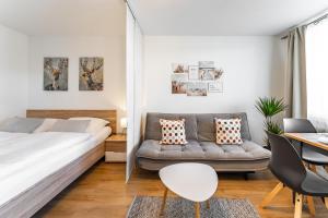 - une chambre avec un lit et un canapé dans l'établissement Billys Apartment Zentrum, Renoviert, Garage, Netflix, à Mondsee
