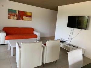 sala de estar con sofá y mesa con sillas en Proa VI - Balcón con Parrillero, en Punta del Este
