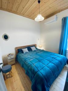 a bedroom with a large blue bed and a wooden ceiling at Malta House in Galaxidi in Galaxidhion