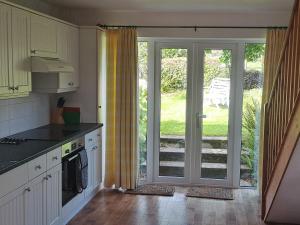 uma cozinha com uma porta aberta para um pátio em Hayway em South Brent