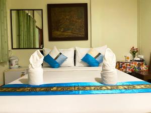 a bedroom with a bed with blue and white pillows at Khaolak Grand City in Khao Lak