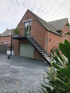 une maison en briques avec un escalier sur son côté dans l'établissement La chambre des daines, à Binche