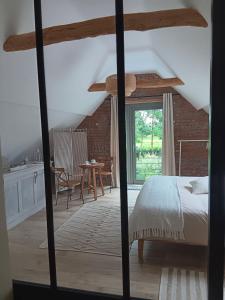 a bedroom with a bed and a table with chairs at La chambre des daines in Binche
