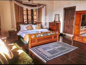 a bedroom with a large wooden bed and a window at Cottage Villa Dalhousie in Dalhousie