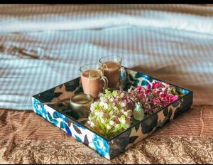 a tray of flowers and two glasses on a bed at Cottage Villa Dalhousie in Dalhousie