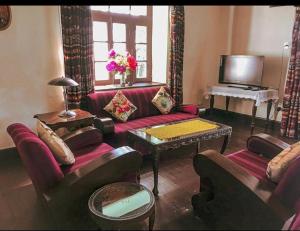 a living room with a couch and a piano at Cottage Villa Dalhousie in Dalhousie
