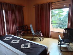 um quarto com uma cama e uma grande janela em World's End Base Eco-Village em Belihuloya