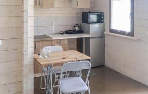 a small kitchen with a wooden table and white chairs at Amazing Home In Rybical With Kitchen in Ryn