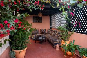 a patio with a couch and some plants and flowers at Surf Riad Taghazout in Taghazout