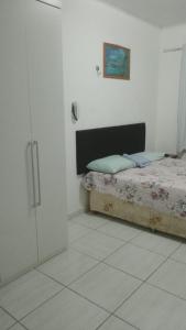 Un dormitorio con una cama y un armario. en Residencial Laranjal, en Manaus