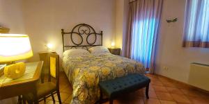 1 dormitorio con 1 cama, 1 mesa y 1 lámpara en Le Civette Country Resort en Bagno a Ripoli