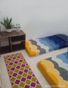 Sintang的住宿－GreenKOST，一间设有床、桌子和地毯的房间