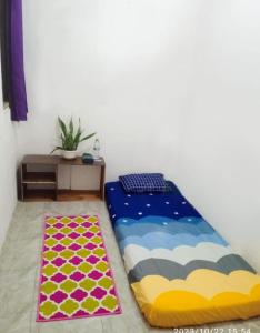 a bedroom with a bed and a rug at GreenKOST in Sintang