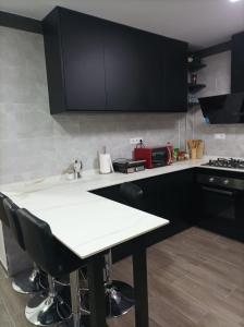cocina con armarios negros y encimera blanca en Alojamiento Alisson, en Villena
