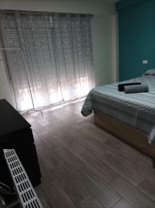 1 dormitorio con 1 cama y suelo de madera en Alojamiento Alisson, en Villena