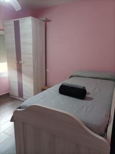 Un dormitorio con una cama con un sombrero negro. en Alojamiento Alisson, en Villena