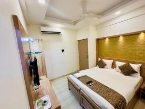 a bedroom with a large bed with a wooden headboard at Stay Court - Business Class Hotel - Near Central Railway Station in Chennai