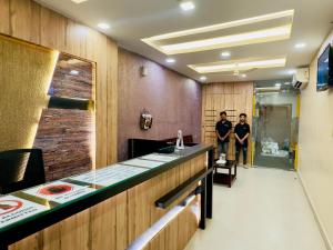 two men standing in a room with a counter at Stay Court - Business Class Hotel - Near Central Railway Station in Chennai