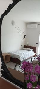 specchio in camera con letto e fiori viola di 'L SASS a Borgomanero