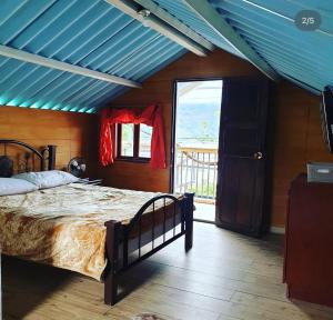 a bedroom with a bed and a blue ceiling at HOSTAL MACONDO in Manizales