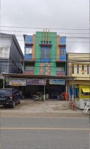 un bâtiment coloré sur le côté d'une rue dans l'établissement GreenKOST, à Sintang