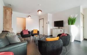 un soggiorno con divani, sedie e TV di Nice Home In De Panne With Kitchen a De Panne