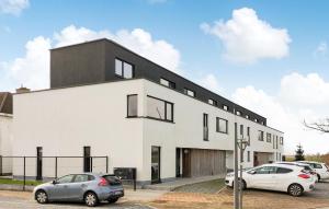 un edificio bianco con due auto parcheggiate in un parcheggio di Nice Home In De Panne With Kitchen a De Panne