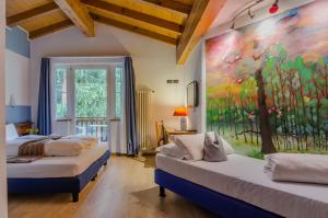 duas camas num quarto com um quadro na parede em Hotel Bella di Bosco em Malè