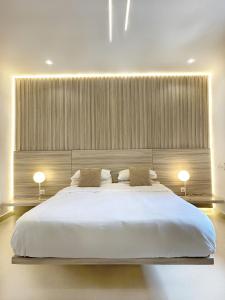 a bedroom with a large white bed with two lamps at Appartement Palms Abidjan in Abidjan