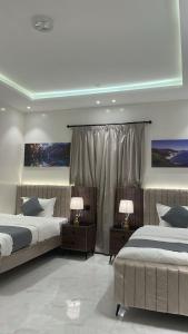 a bedroom with two beds and two lamps on tables at شقق ثمانين بارك 2 in Khamis Mushayt
