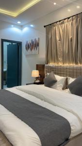 a bedroom with a large bed and a window at شقق ثمانين بارك 2 in Khamis Mushayt