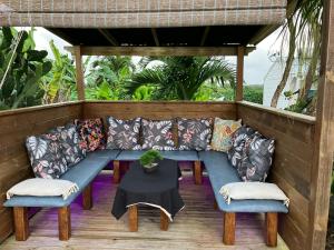 - un canapé, 2 chaises et une table sur une terrasse couverte dans l'établissement Gîte Ty Koko, à Saint-François