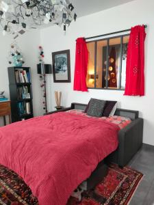 ein Schlafzimmer mit einem Bett mit einer roten Decke in der Unterkunft La suite 27, chambre d'hôtes de charme in Guingamp