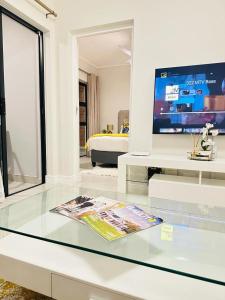 a living room with a glass table and a tv at Coastal Retreats in Ballito