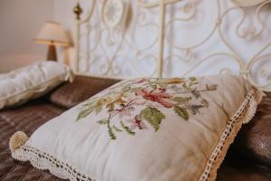 ein Bett mit einem Kissen mit Blumenmuster darauf in der Unterkunft La Casa di Alice in Villa San Secondo