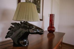 a table with a lamp and a horse head on it at La Casa di Alice in Villa San Secondo