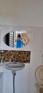 a woman taking a picture of herself in a bathroom mirror at Serra da Canastra - Casa em Vargem Bonita/MG in Vargem Bonita