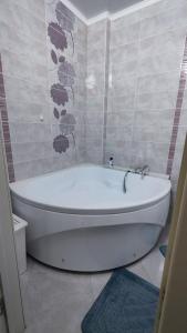 a white bath tub sitting in a bathroom at Kamal Apart in Prigorodnyy