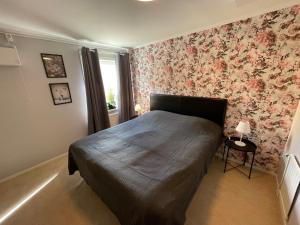 a bedroom with a bed with a floral wallpaper at Bakgårdens Vandrarhem in Mariestad