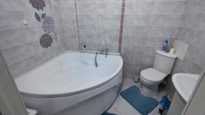 a bathroom with a white tub and a toilet at Kamal Apart in Prigorodnyy