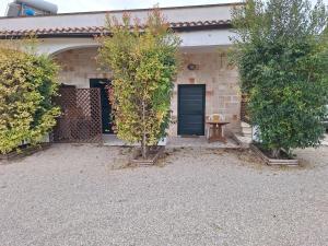 dom z dwoma drzewami przed drzwiami w obiekcie Appartamento Porto Cesareo w mieście Porto Cesareo