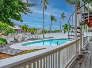 a swimming pool with a white fence and a swimming poolvisor at Florida Life on the Water. Heated Pool, fishing, kayaks, gameroom in Palm Harbor